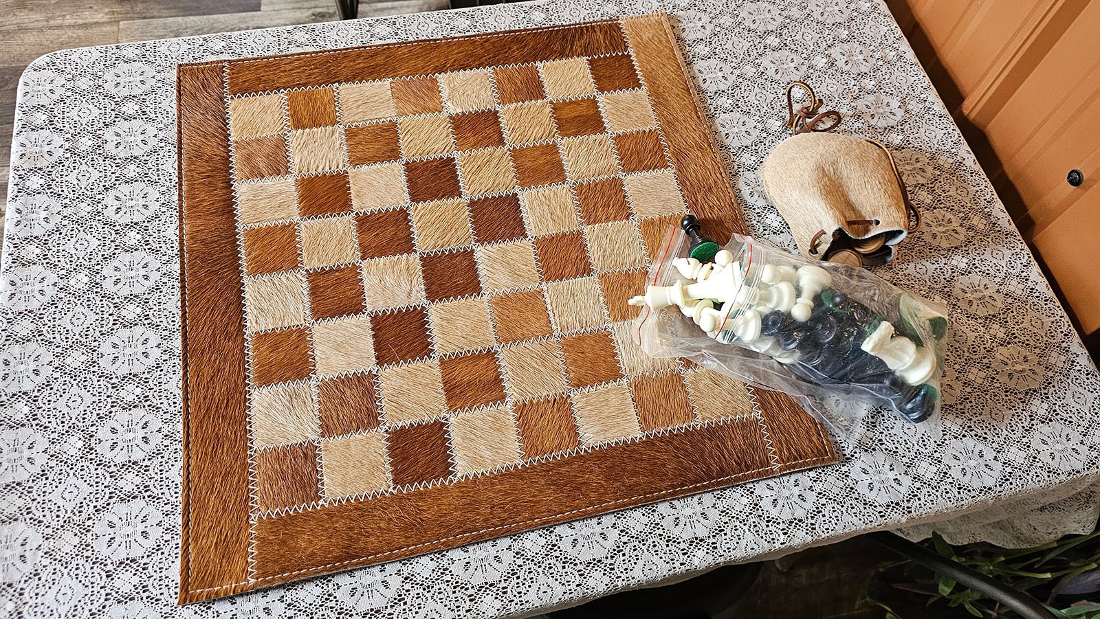 Un tablero de ajedrez de cuero crudo invita a jugar una partida de ajedrez o damas.