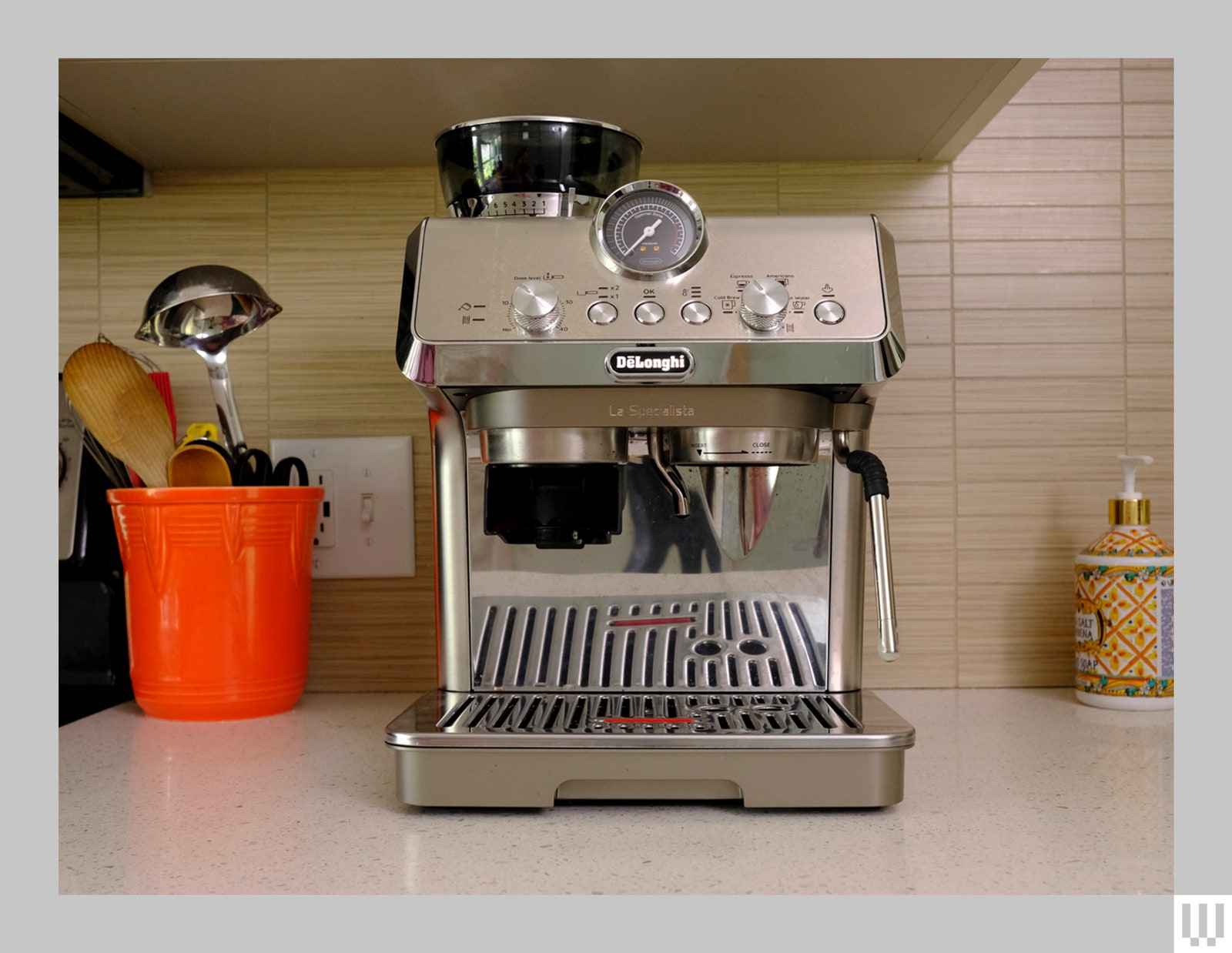 Vista frontal de la máquina de café espresso casera plateada sobre la encimera