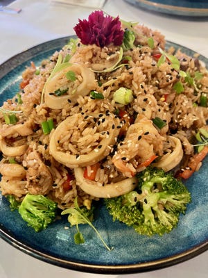 La combinación de mezcla de arroz chaufa en Sunqu Delights of Peru está repleta de mariscos, pollo y carne de res.