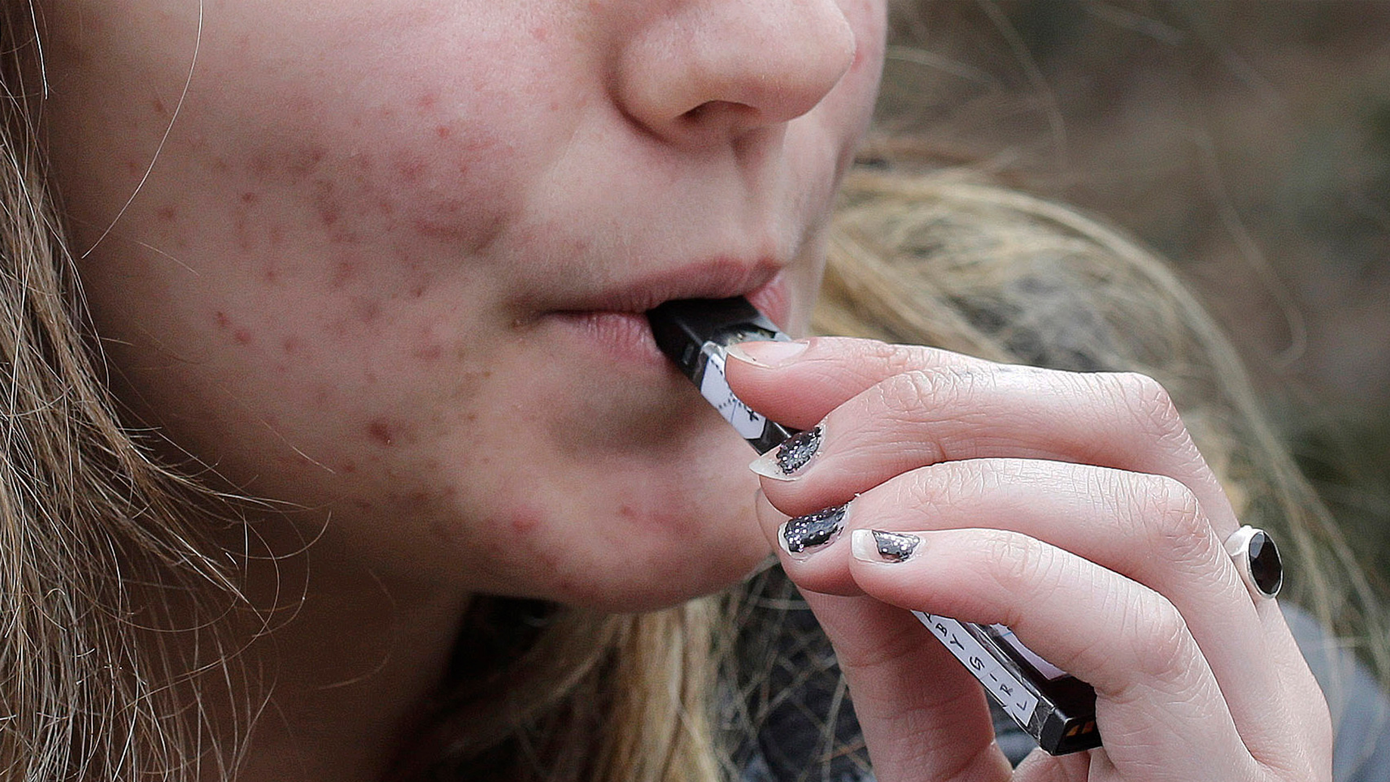 Un estudiante de secundaria usa un dispositivo de vapeo cerca del campus de una escuela en Cambridge, Massachusetts, el 11 de abril de 2018.